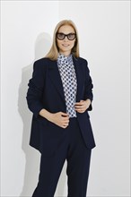 Studio portrait of a modern confident woman in a navy blue classic fitted suit