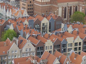 Bird's eye view of a row of houses with classic red roofs and different facades, together with a