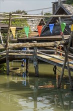 Wooden bridge with colourful pennants over a canal on the floating market, Pattaya, Thailand, Asia