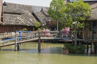 Wooden bridge and traditional houses around a quiet canal at the floating market, Pattaya,