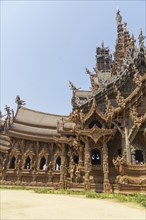 Wide-angle view of a section of the wooden temple, with detailed decorations and sculptures, blue