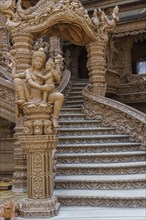 Close-up of an ornate wooden staircase inside the temple, with sculptures and carvings, Pattaya,