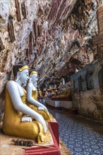 Religious carvings on limestone rock and colourful Buddha statues