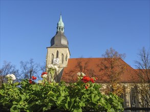 Church tower and blooming flowers, autumn leaves and blue sky, peaceful atmosphere, nottuln,