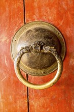 Golden door knob on a red wooden door