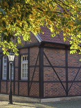 Half-timbered house with brick walls and lantern, surrounded by autumn leaves, nottuln,