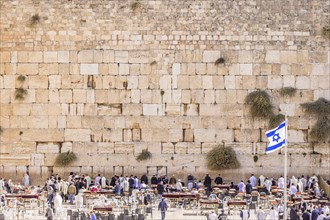 The Western wall in Jerusalem with state flag of Israel