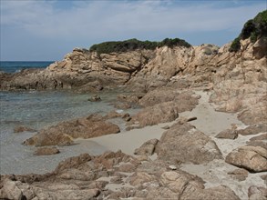 Rocky coastline with a strip of sand and dense vegetation bordering the sea, ajaccio, corsica,