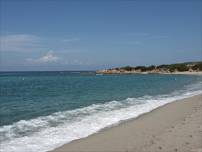 White sandy beach with gentle waves and turquoise-coloured water, ajaccio, corsica, france