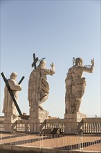 Back view of statues of the saints apostles located on the top of St Peter Basilica roof
