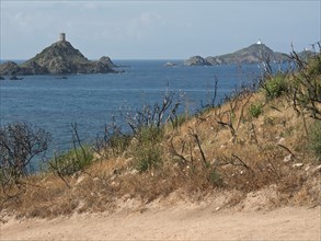 View of two islands in the sea, surrounded by barren hills and withered vegetation in the