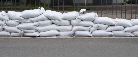 Sandbags for flood defense, river Moselle Trier in Rhineland Palatinate, flooded trees and paths,