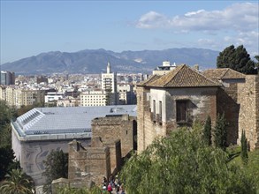 Panoramic view of a city with mountains in the background and historic buildings in the foreground,