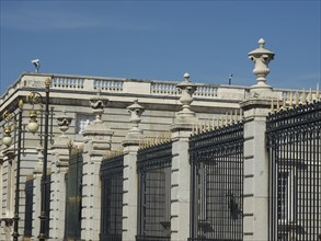 A historic wall with a pointed fence and golden decorations in beautiful weather, Madrid, Spain,