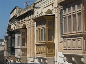 Traditional buildings with different coloured balconies in daylight, gozo, mediterranean sea, malta