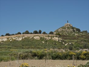 Statue on a green hill under a clear blue sky, gozo, mediterranean sea, malta