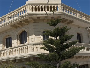 Elegantly decorated building with balconies and windows against a blue sky, Gozo, Mediterranean,