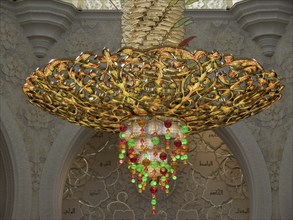 Gilded chandelier with green and red decorations in a magnificent room, abu dhabi, united arab