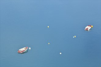 Two boats and buoys in the reservoir Lac de Sainte-Croix in the turquoise water near