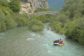 Stone arch bridge Pont du Roc built in the 15th century over the river Verdon with rafting group in