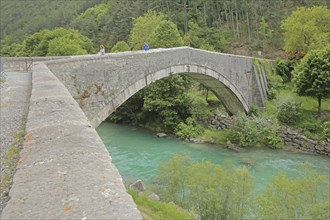 Stone arch bridge Pont du Roc built 15th century over the river Verdon, tourists, Castellane,