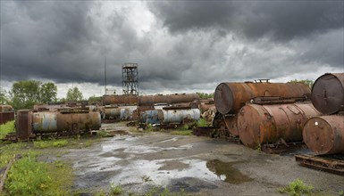 Rusty tanks and pipes in an abandoned junkyard under a cloudy sky, symbol photo, AI generated, AI