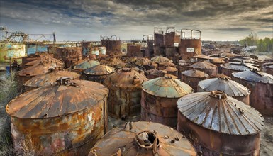 A collection of rusted tanks in a junkyard under a cloudy sky, symbol photo, AI generated, AI