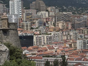 Dense urban development with an old fortress and modern architecture in the background, monte