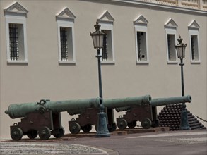 Row of historical cannons and bullets in front of a guarded building, monte carlo, monaco, france