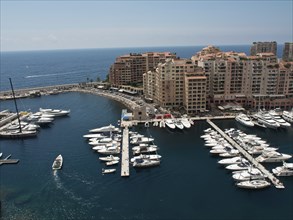 Aerial view of a harbour with numerous boats and surrounding multi-storey buildings, monte carlo,