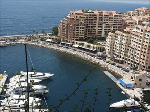 View of a coastline with luxurious flat blocks and numerous yachts and boats in the water, monte