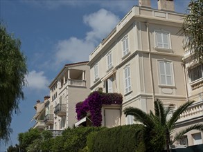 Building facade with balconies and flowering plants under a clear sky, monte carlo, monaco, france