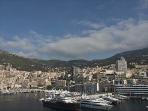 Panoramic view of a harbour with many boats and a town and mountains behind, monte carlo, monaco,