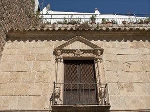 Historic building with stone façade and balcony in rustic architecture, ibiza, mediterranean sea,