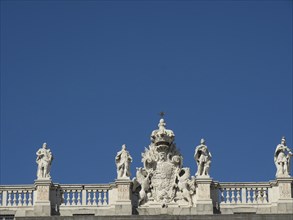Decorative building with numerous sculptures and ornaments under a cloudless sky, Madrid, Spain,