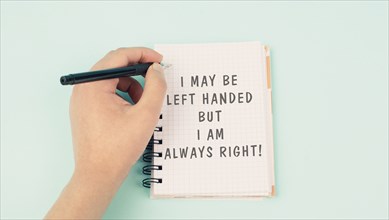 I may be left handed but I am right is standing on a notebook, writing with the left hand, pen and