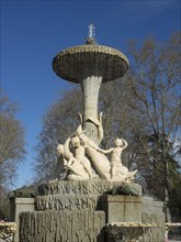 Large, artistic fountain with water jets and sculptures in the park under a blue sky, Madrid,