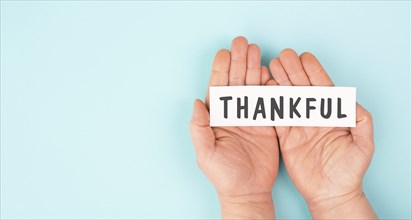 Thankful sign in hand, thank you, support, help and charity concept, positive attitude