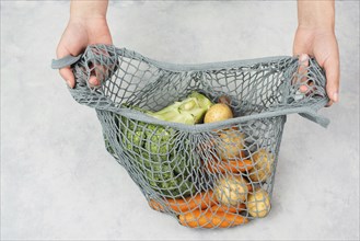 Mesh bag with vegetables, shopping grocery, healthy food ingredients, potato, broccoli and carrots,