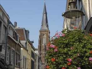 City street with a view of a church, colourful flowers and historic buildings on a sunny day,