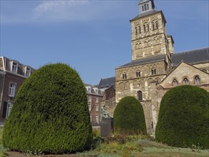 An attractive garden with well-kept hedges in front of a historic church building, Maastricht,