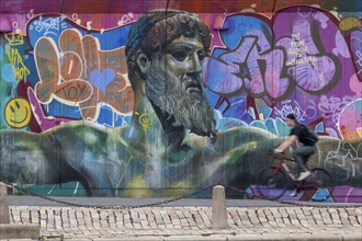 God of Greek mythology, Zeus, large graffiti on building fence, cyclist, harbour, Gothenburg,