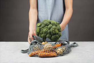 Mesh bag with vegetables, shopping grocery, healthy food ingredients, potato, broccoli and carrots,