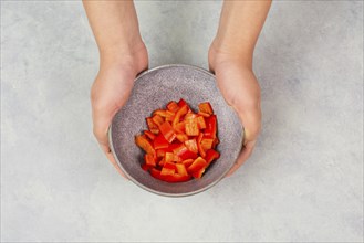Tomatoes and red sliced pepper pieces in a bowl, prepare healthy food with paprika vegetables,