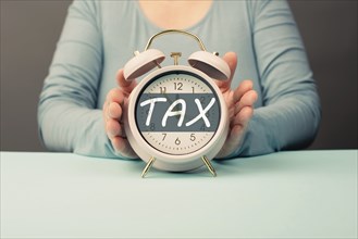 Tax time, alarm clock for taxation, deadline for payment, financial income, return of taxes