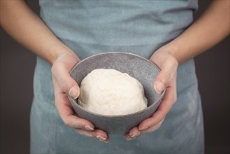 Fresh wheat dough, baker holds bowl with flour, bread or pizza, prepare ingredients for food,