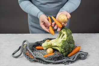 Mesh bag with vegetables, shopping grocery, healthy food ingredients, potato, broccoli and carrots,