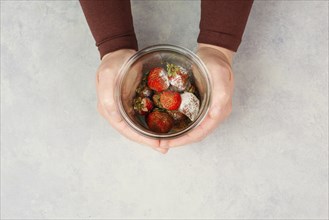 Moldy strawberry fruits with spot fungus in a jar, rotten strawberries, decomposition of the food