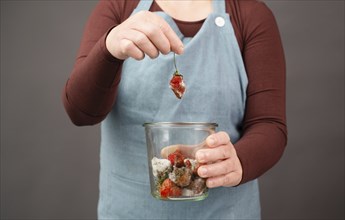 Moldy strawberry fruits with spot fungus in a jar, rotten strawberries, decomposition of the food