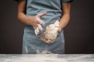 Baker kneading dough for pizza or artisan bread with his hands, prepare ingredients for food,